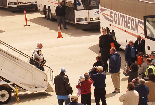 Roy Williams emerges from plane with trophy.